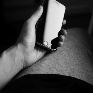 Gay phone sex client holding mobile phone