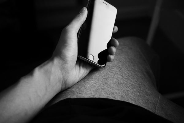 Gay phone sex client holding mobile phone